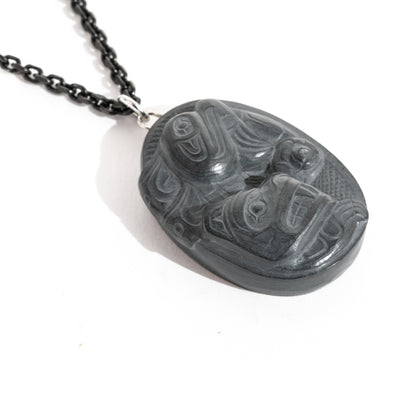 Close up of left side of Black Argillite Sea Bear pendant necklace with intricate Haida Carvings on a white background made by Local Haida Gwaii Artist Melanie Russ
