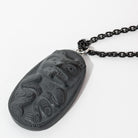 Close up of right side of Black Argillite Bear pendant necklace with intricate Haida Carvings showcasing the 3-d depth of the carving on a white background made by Local Haida Gwaii Artist Melanie Russ
