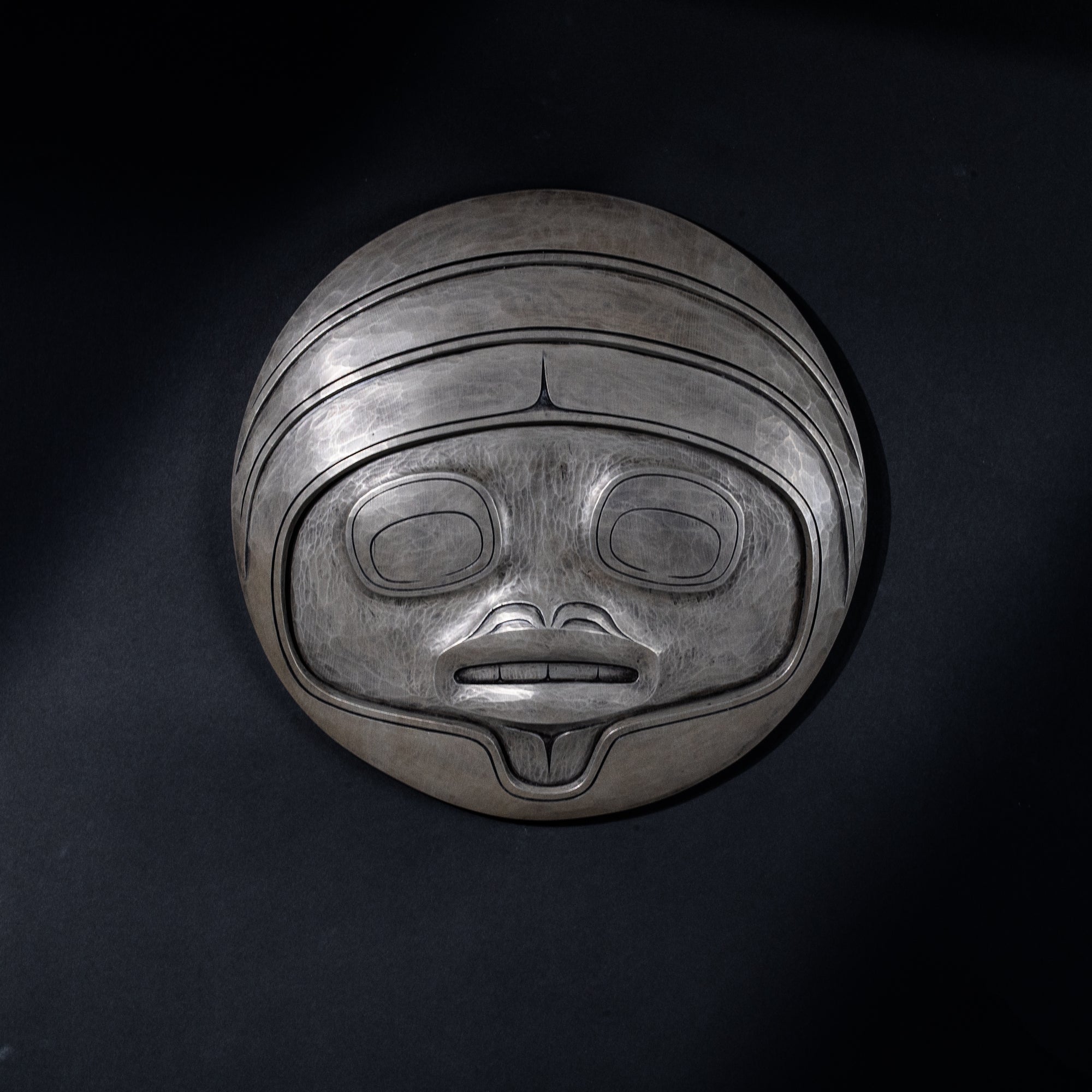 Fungus man mask casting with intricate carvings by Cori Savard on a dark black background