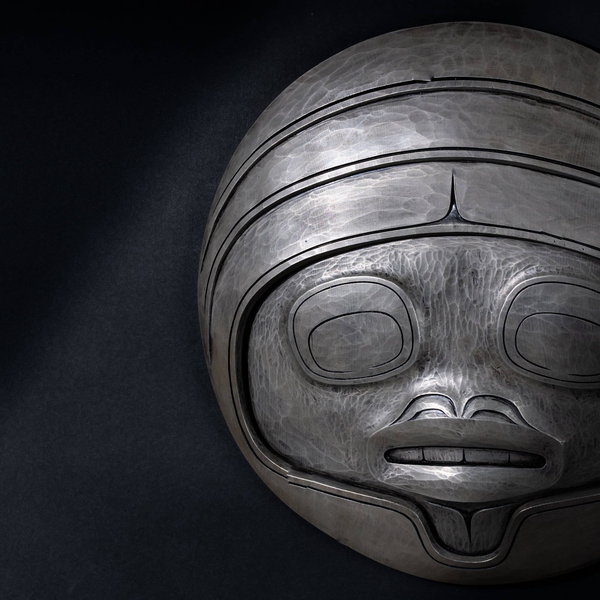 Close up of Fungus man mask casting with intricate carvings by Cori Savard on a dark  background