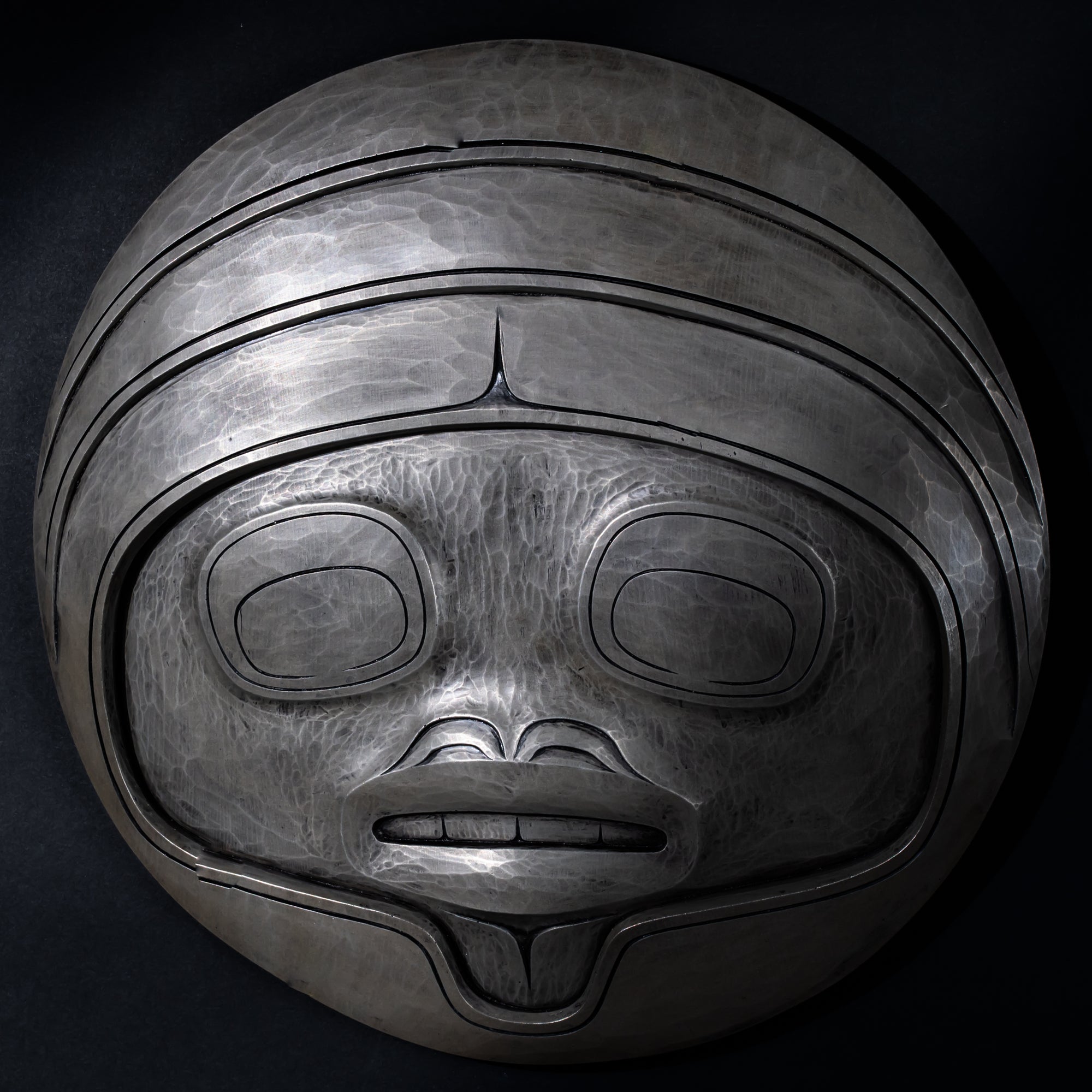 Fungus man mask casting with intricate carvings by Cori Savard on a dark wooden background