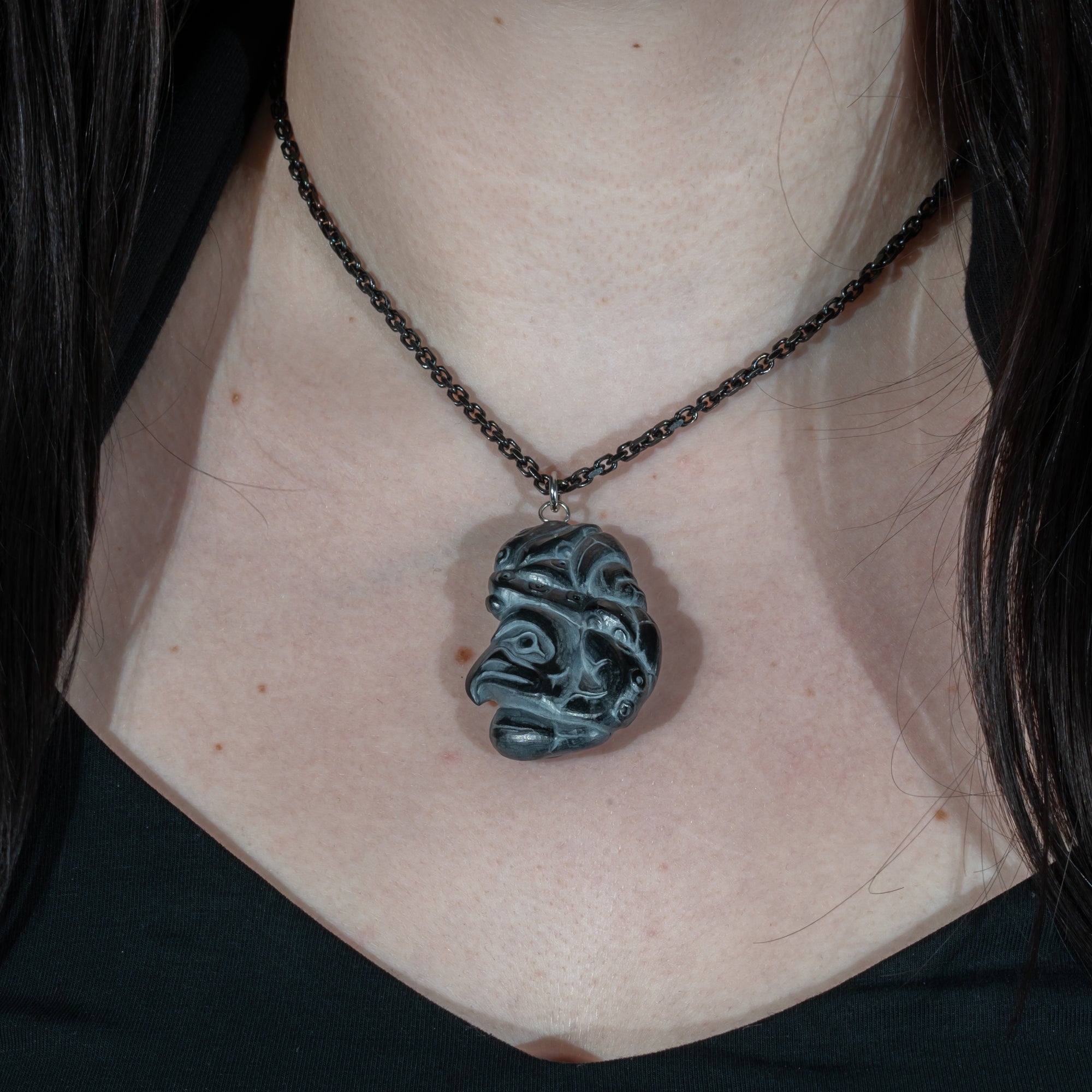 Close up second side of Black Argillite Octopus pendant necklace with intricate Haida Carvings on a white background made by Local Haida Gwaii Artist Melanie Russ