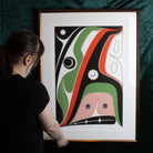 Framed Hope Print by Robert Davidson held by a model with a green background