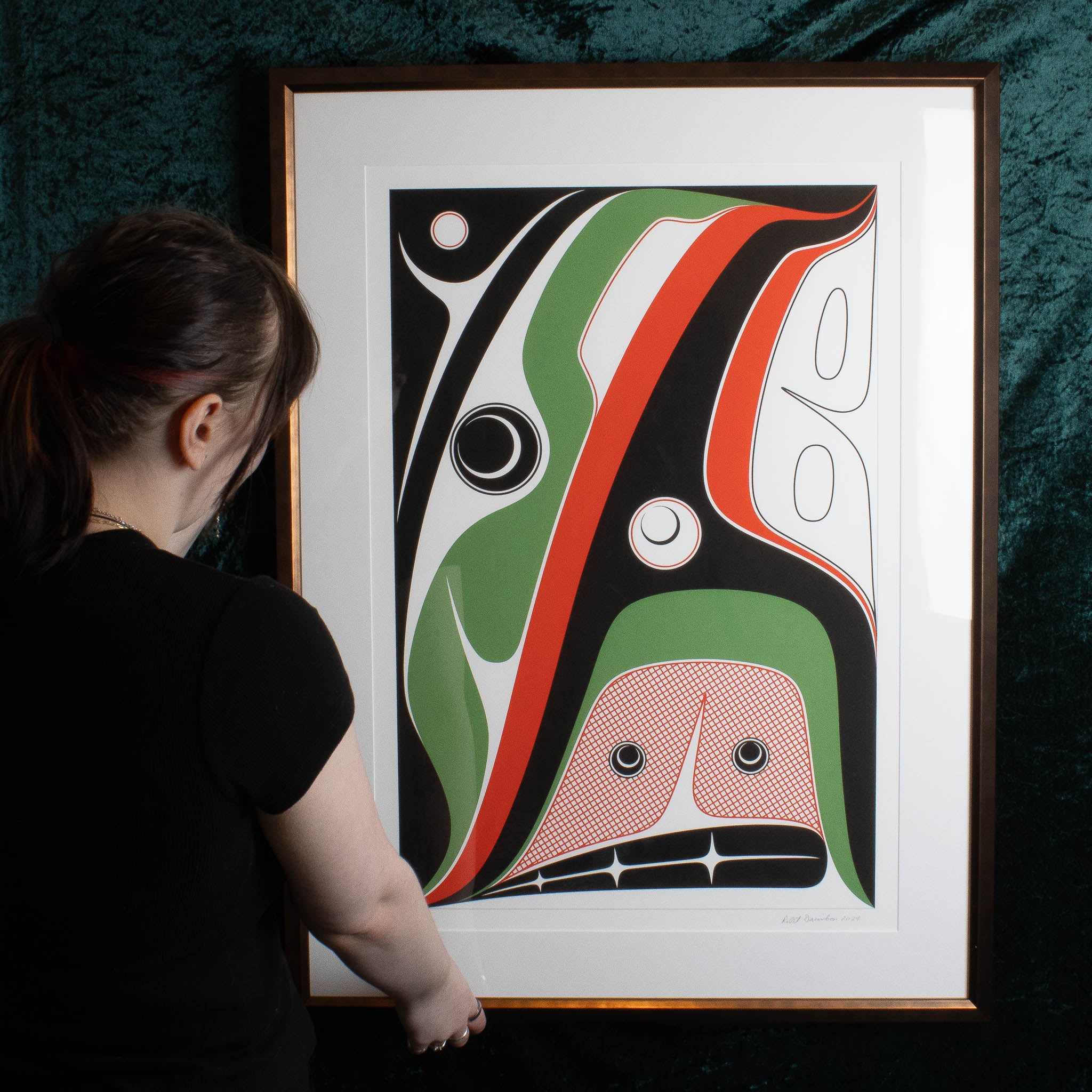 Framed Hope Print by Robert Davidson held by a model with a green background
