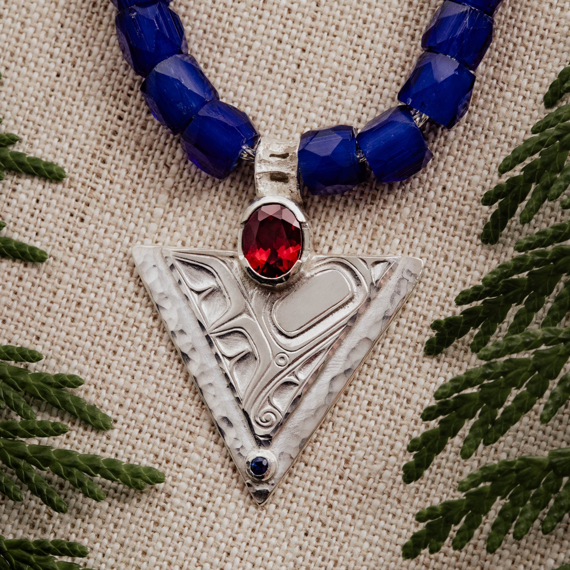 Sterling-Silver-Hummingbird-Pendant-with-Blue-Beads-Close-up-Linen-Backdrop