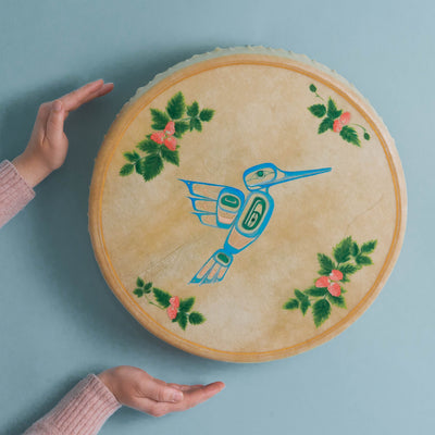 Round canvas with a blue bird design and green leaves with berries on a light blue background.
