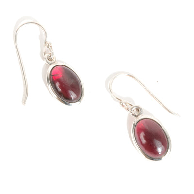 Silver earrings with red garnet gemstones  for January's birthstone on a white background