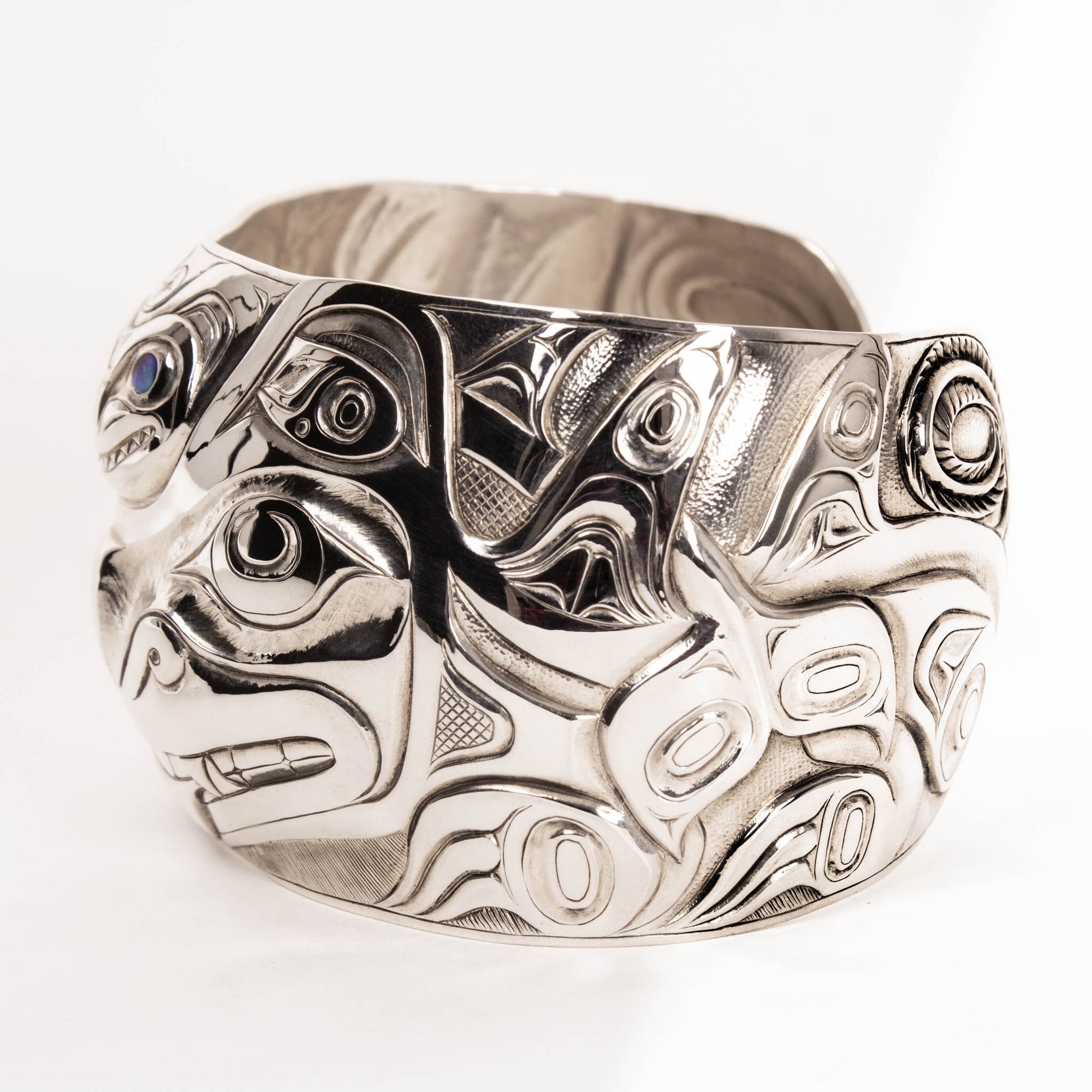 Silver bracelet with intricate designs on a white background