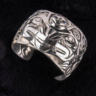 Sterling Silver Wasco and Killer Whale Repousse Bracelet by Jesse Brillon (Haida) on black background