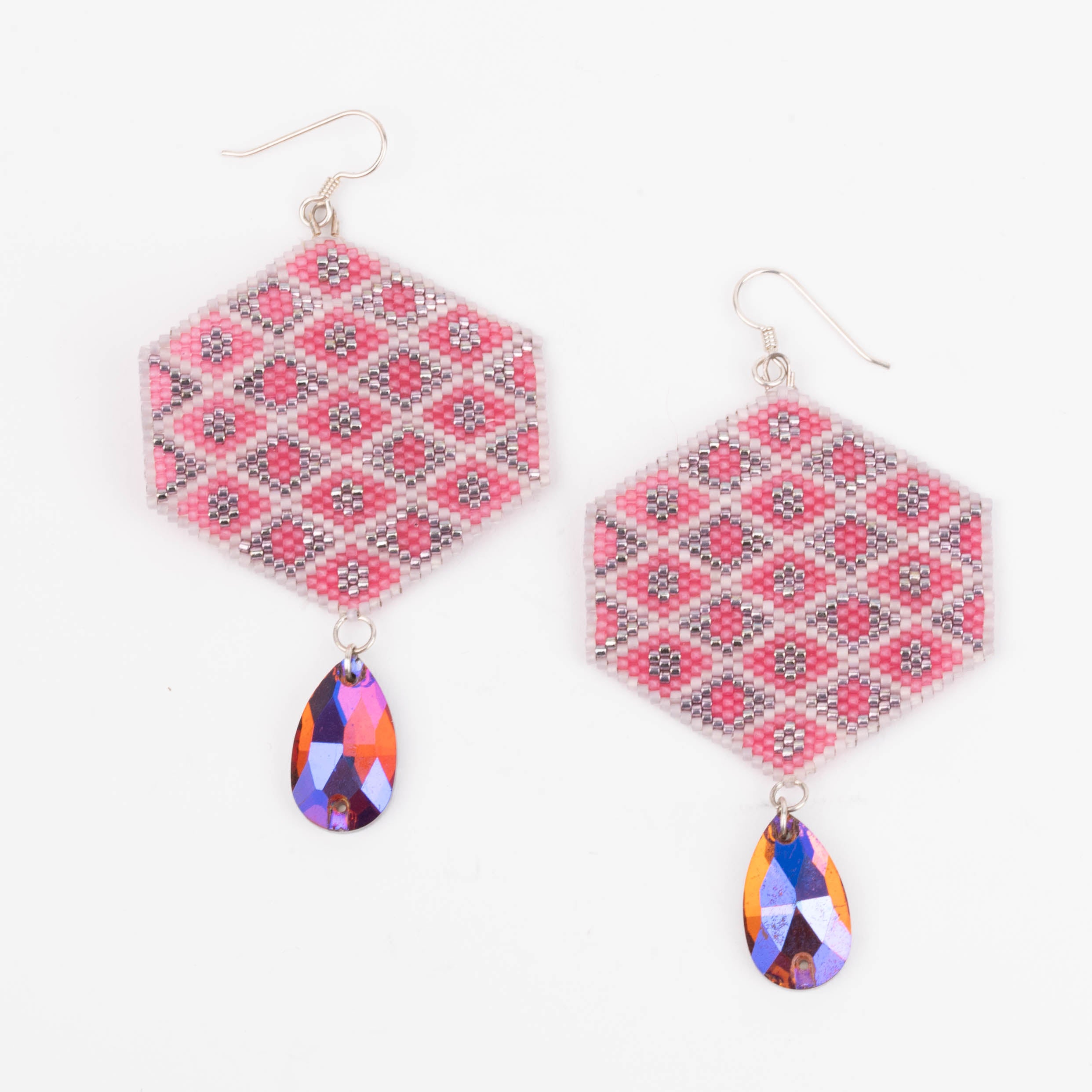 Pink beaded earrings with colorful teardrop pink charms on a white background