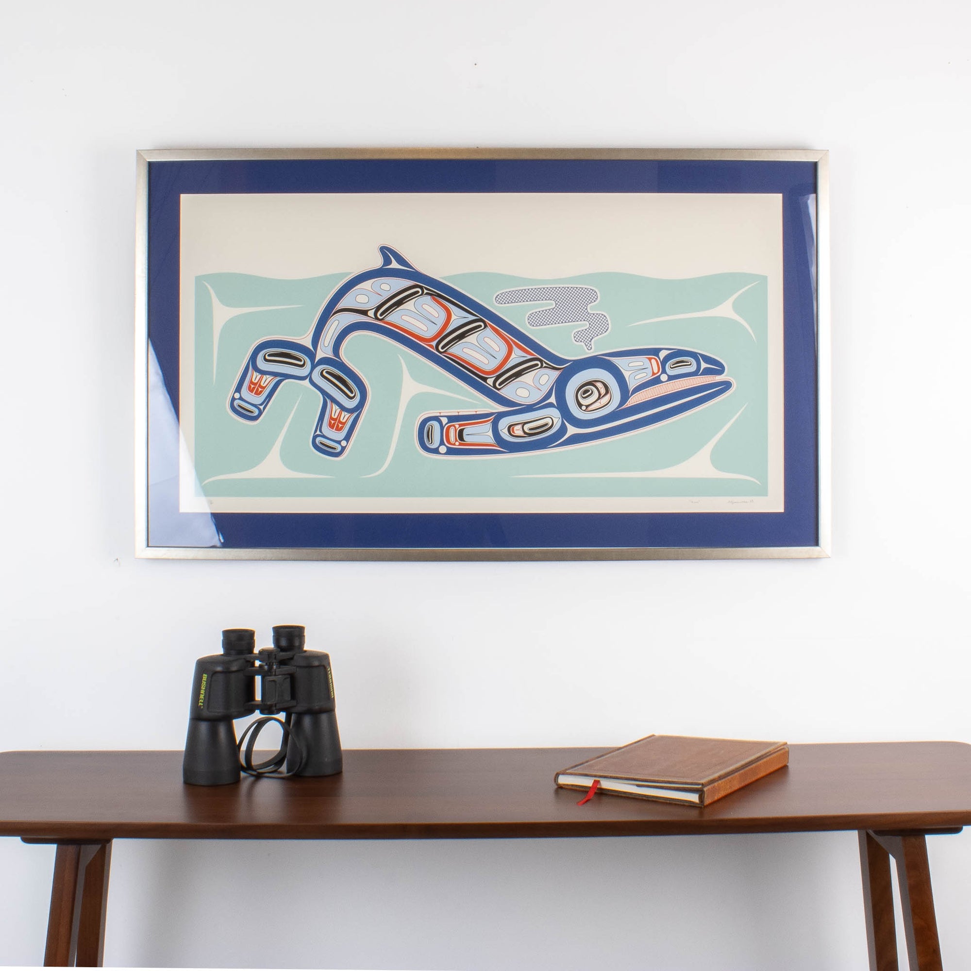Kun (whale) Fine art print, showcasing a whale swimming through the ocean in Haida Formline. Set in an Interior design