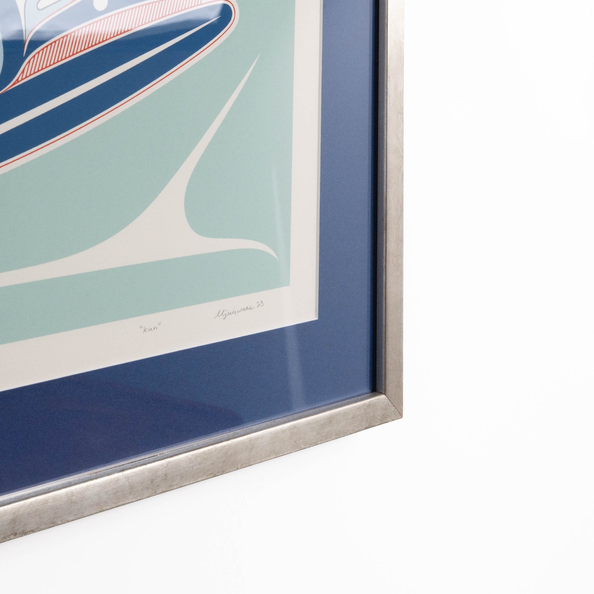 Framed artwork of a stylized Haida Formline Whale swimming through the water with abstract patterns with a blue border and white frame on a white background