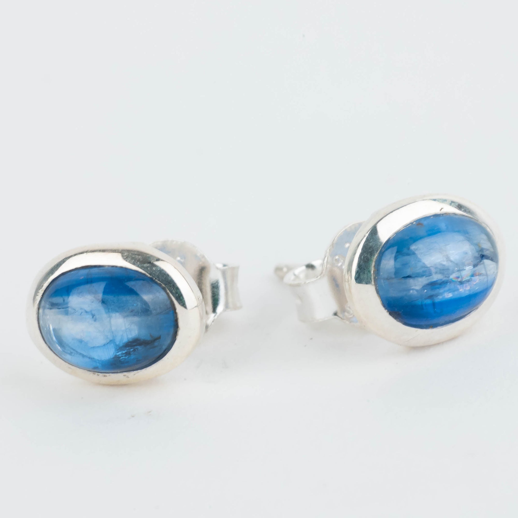 Pair of blue stone stud earrings on a light gray background
