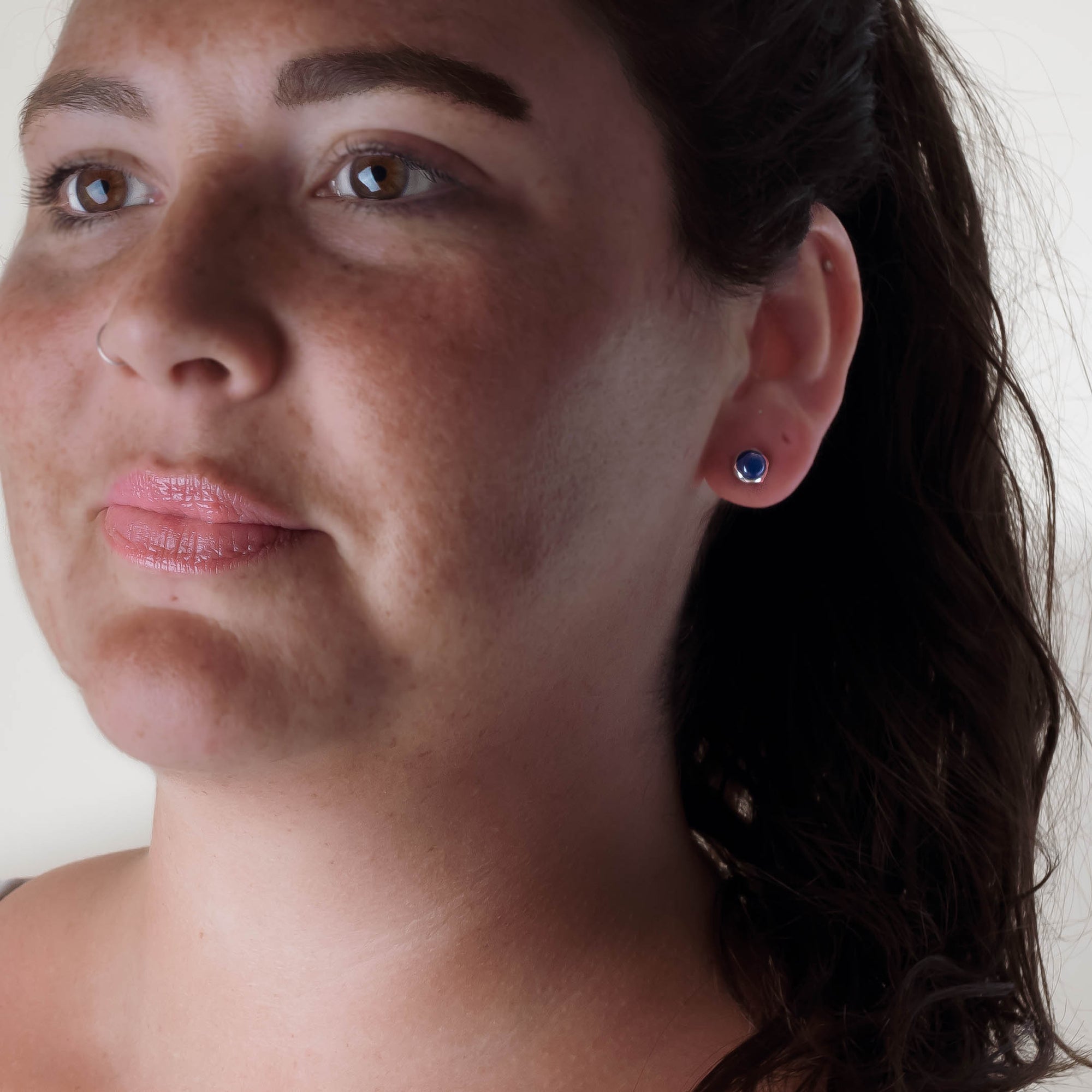 Close-up of a woman wearing earrings with a neutral background