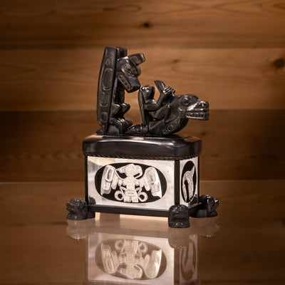 Haida argillite killer whale and thunderbird argillite and sterling silver box done by Haida artist Ding Hutchingson on a dark wood background