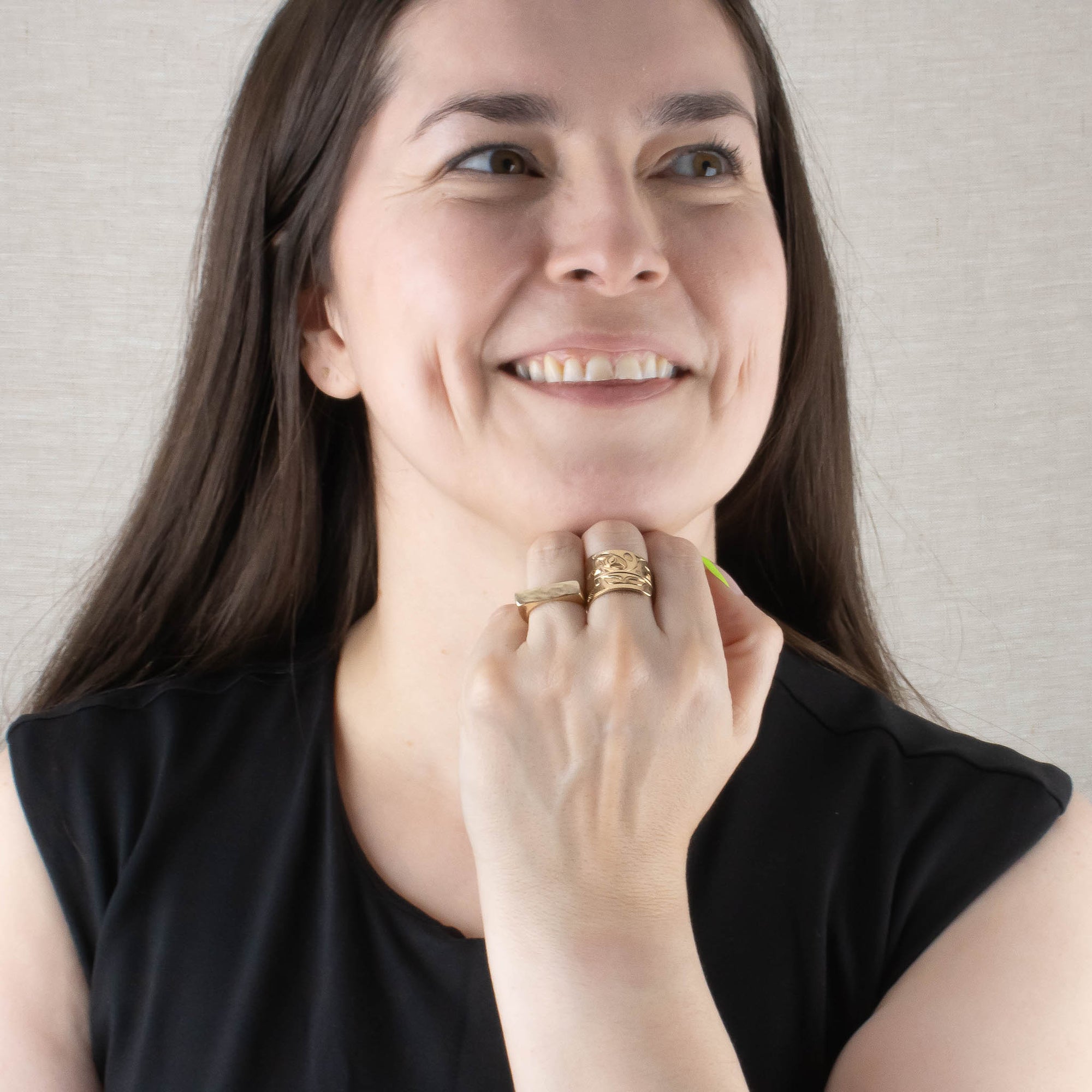 Model wearing gold wide orca wrap ring and a narrow gold signet ring
