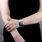 Model wearing wide orca sterling silver bracelet by James Sawyer