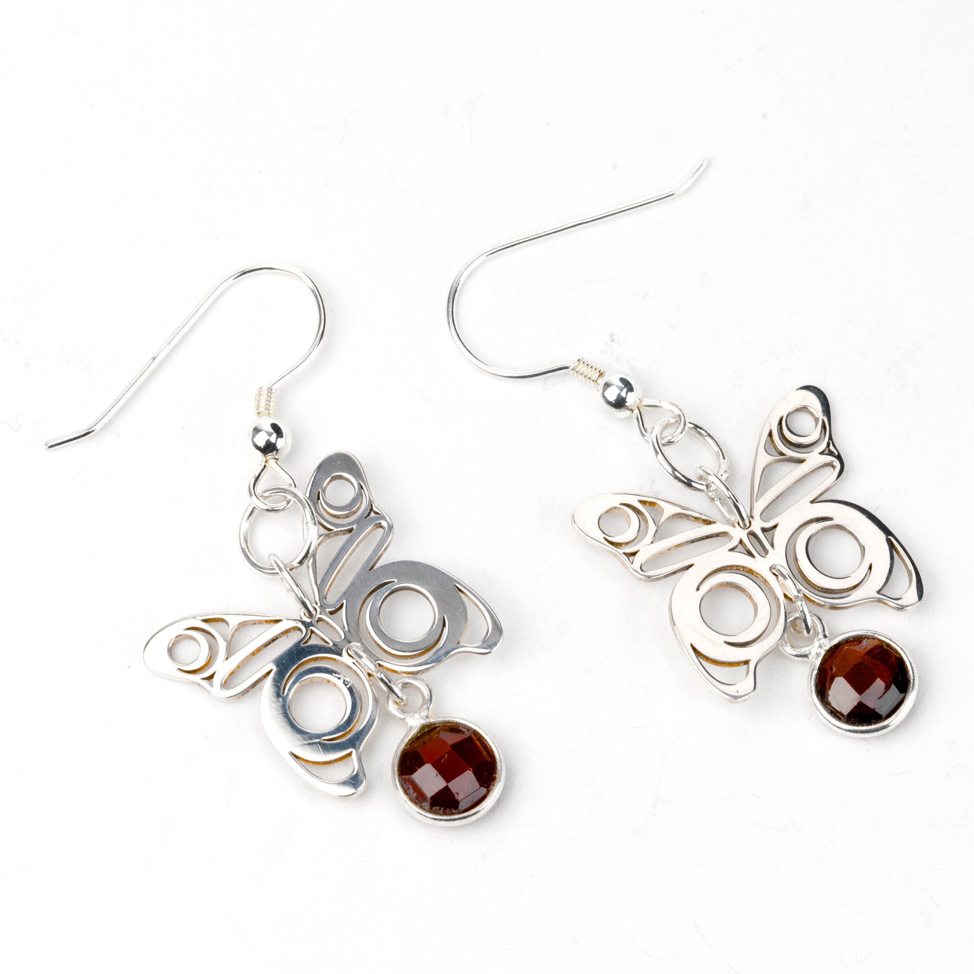 Butterfly-shaped earrings with gemstones on a white background