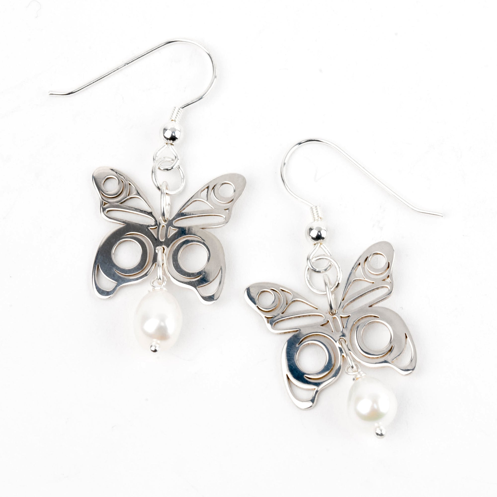 Butterfly-shaped earrings with pearl accents on a white background