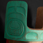 Close-up of a teal and cedar Mouse Woman mask with teal top and black and red face done by Haida artist Corey Bulpitt on a black background