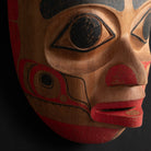 Close up oOrnate Cedar Mouse Woman mask with teal top and black and red face done by Haida artist Corey Bulpitt on a black background 