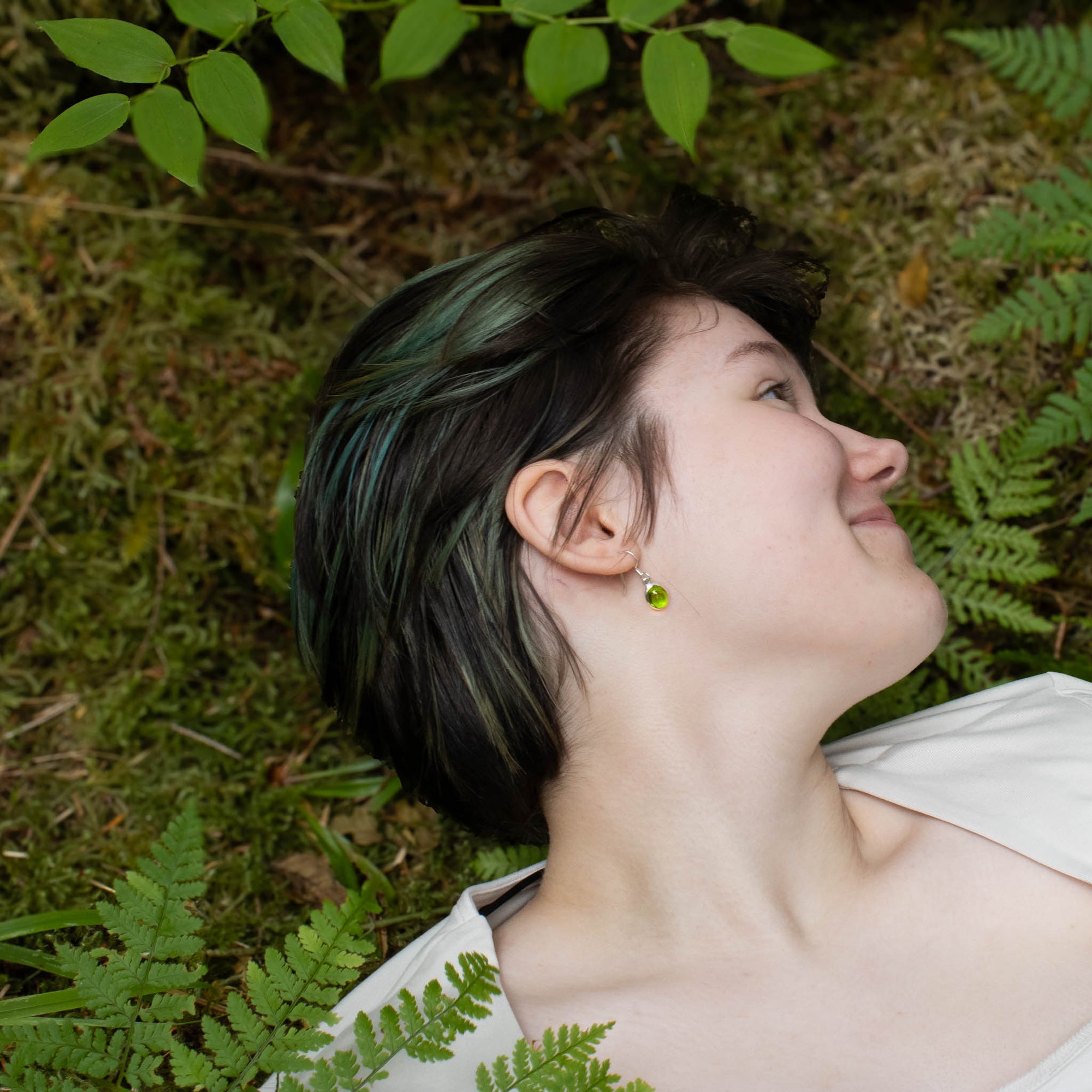 Person lying on the grass with greenery around