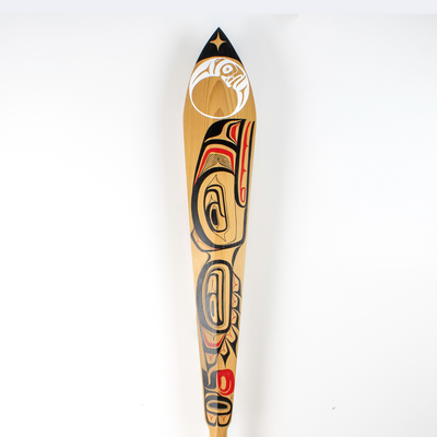 Edge of a wooden paddle with painted design
