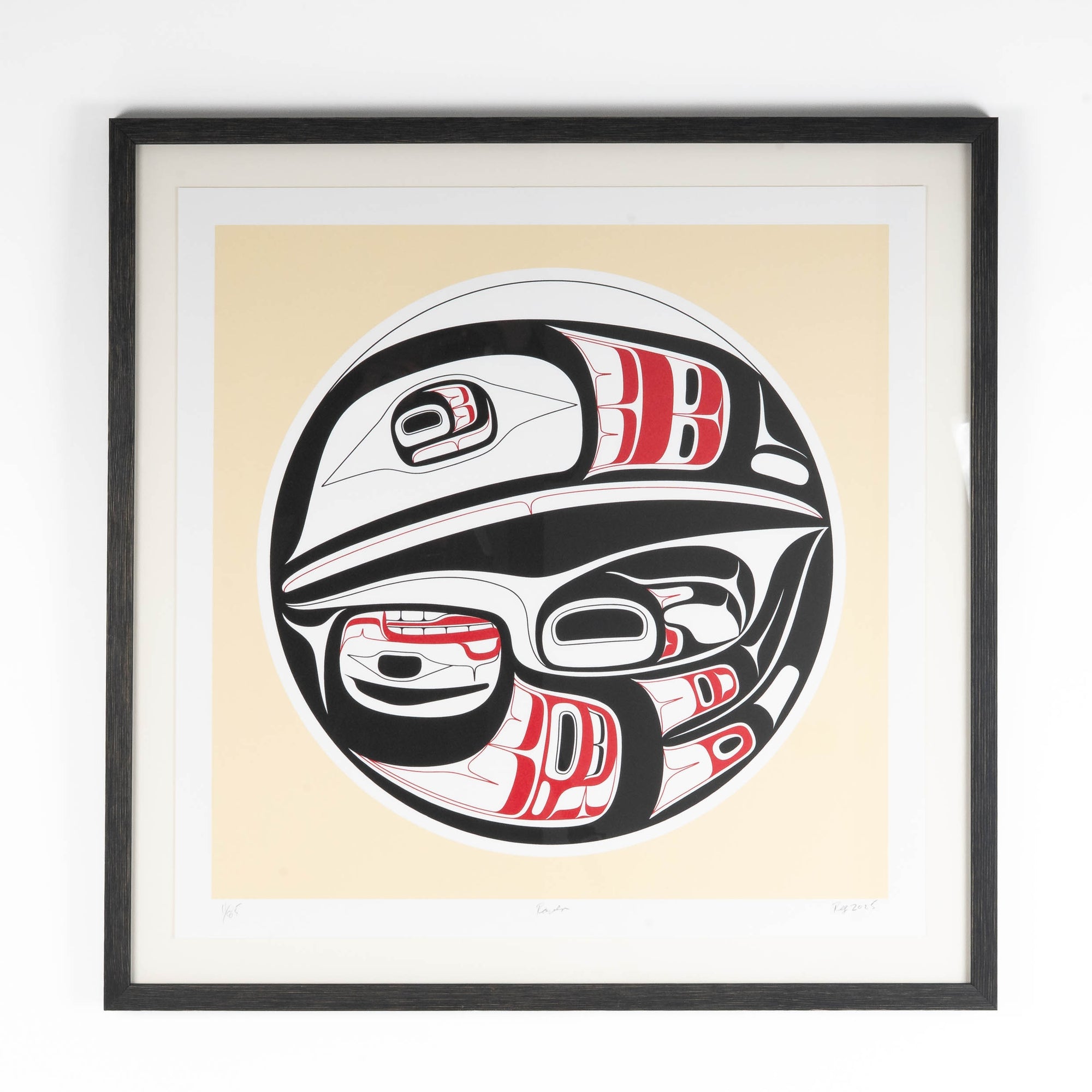 Framed artwork of a stylized formline raven with red and black patterns on a beige background