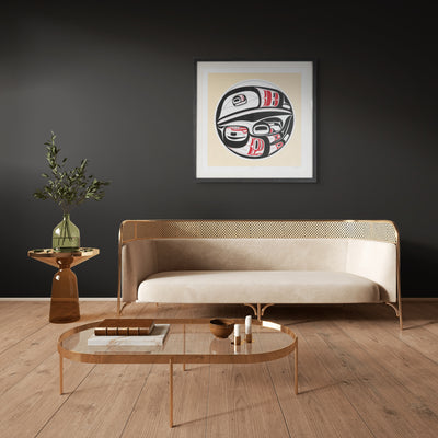 Modern living room with a beige sofa, coffee table, side table, and decorative Haida formline wall art.