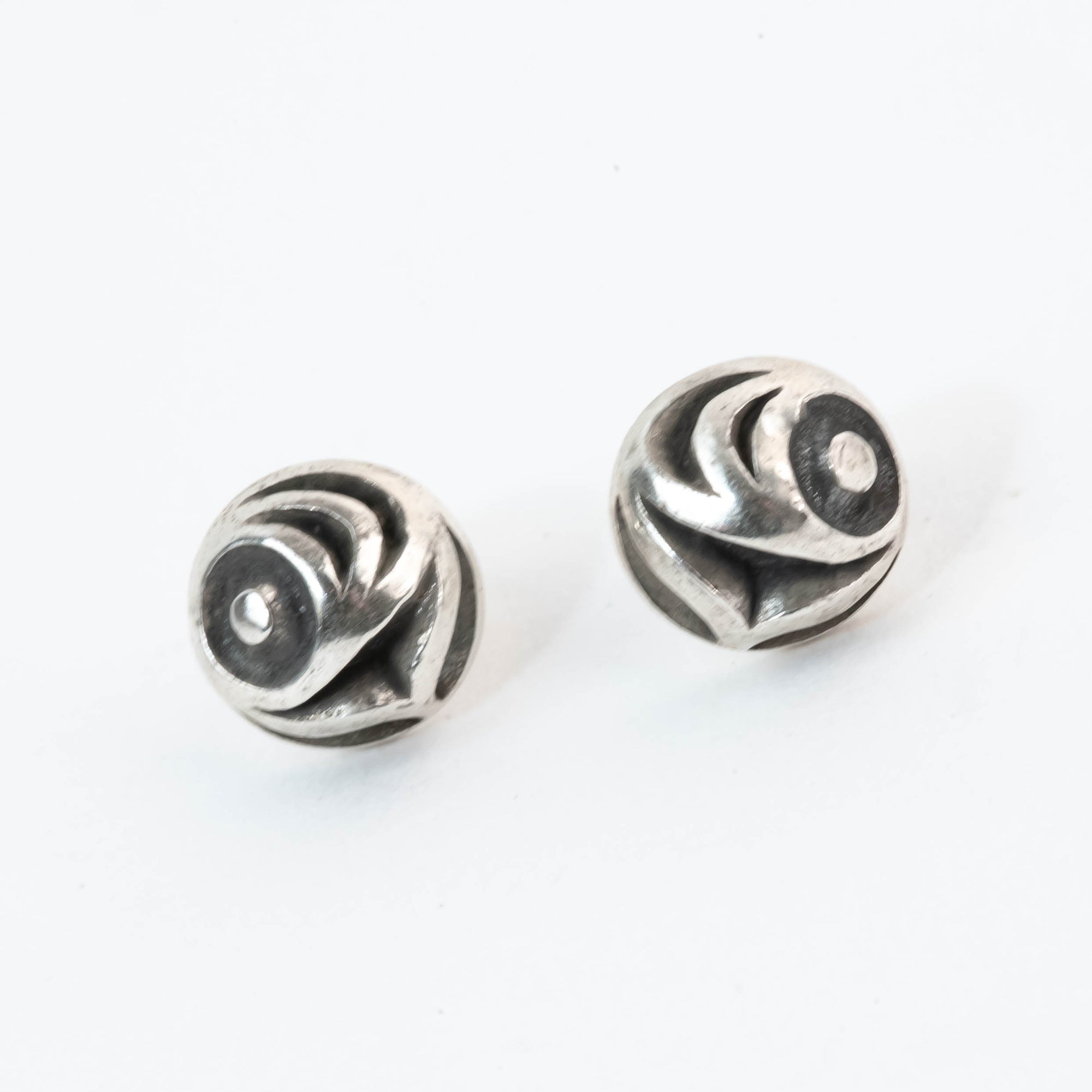 Pair of silver spiral earrings on a white background
