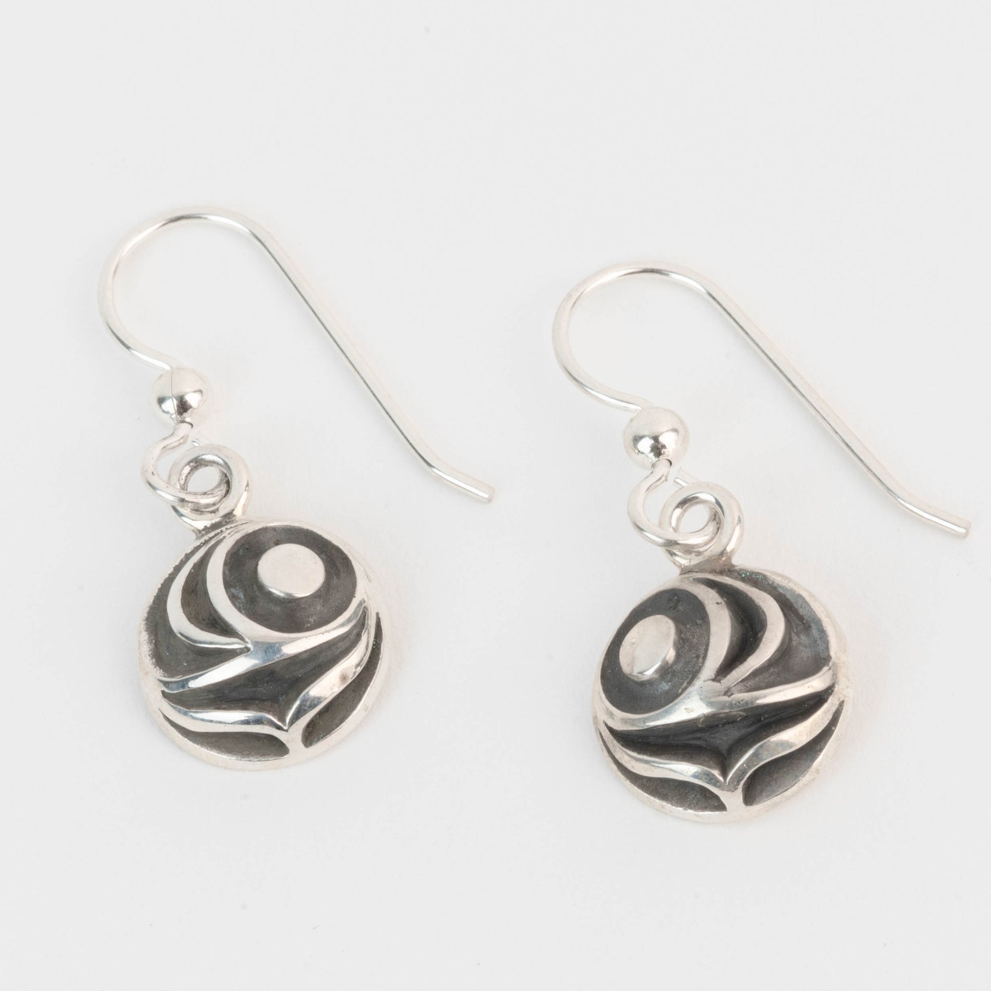 Pair of silver salmon egg earrings with black and white pattern on a light gray background by Indigenous Canadian Artist Meaghan Mcrae