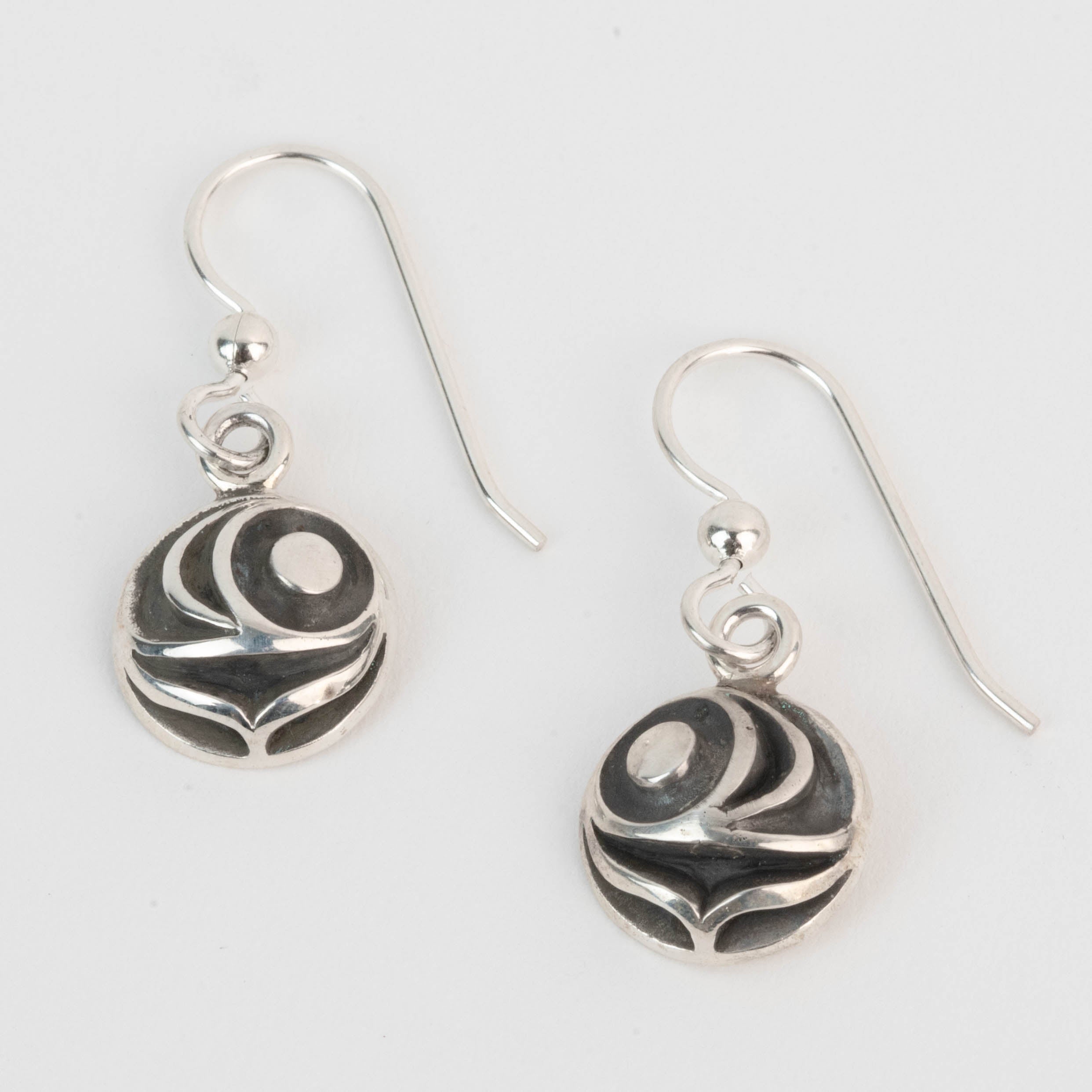 Pair of silver salmon egg earrings with black and white pattern on a light gray background by Indigenous Canadian Artist Meaghan Mcrae