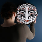 Sea Grizzly panel by Local Haida Gwaii artist Shoshannah Green hand painted on wood. In traditional black red and white. Held by model admiring it