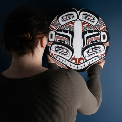 Sea Grizzly panel by Local Haida Gwaii artist Shoshannah Green hand painted on wood. In traditional black red and white. Held by model admiring it