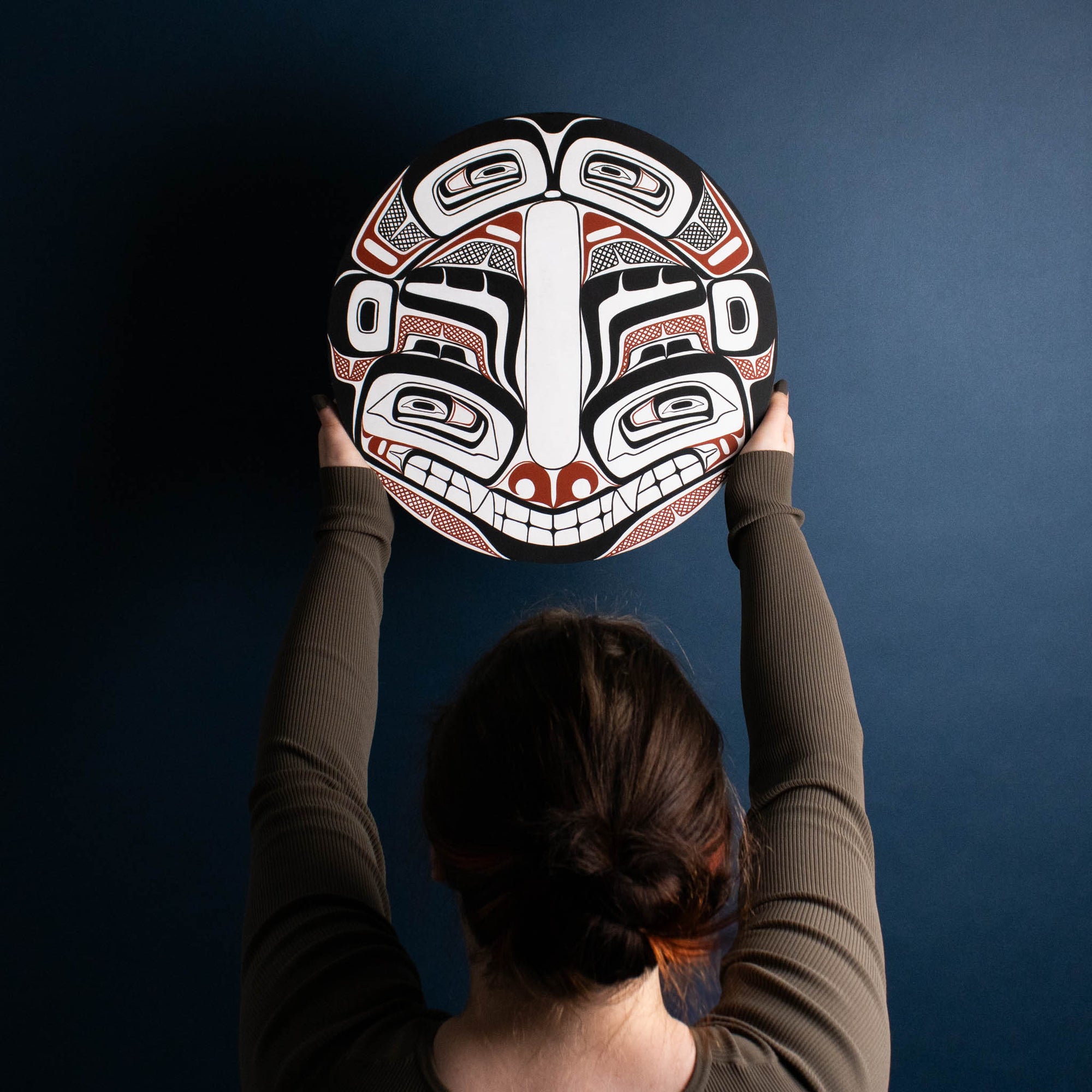 Sea Grizzly panel by Local Haida Gwaii artist Shoshannah Green hand painted on wood. In traditional black red and white held by model placing on the wall