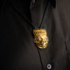 Gold Shaman pendant on a black chain against a dark background