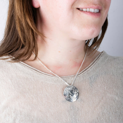 Silver northwest coast hummingbird pendant worn by model side view
