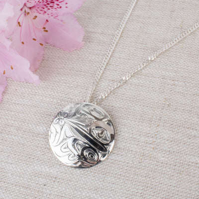 Sterling silver northwest coast hummingbird pendant with pink flower in the corner