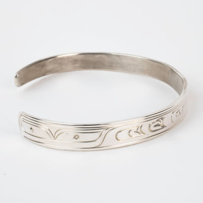 Side view Sterling silver Bracelet featuring  14k gold formline orca head, with mountains, ocean, sun, and trees hand carved around the bracelet
