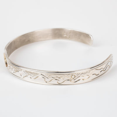 Side view Sterling silver Bracelet featuring  14k gold formline orca head, with mountains, ocean, sun, and trees hand carved around the bracelet