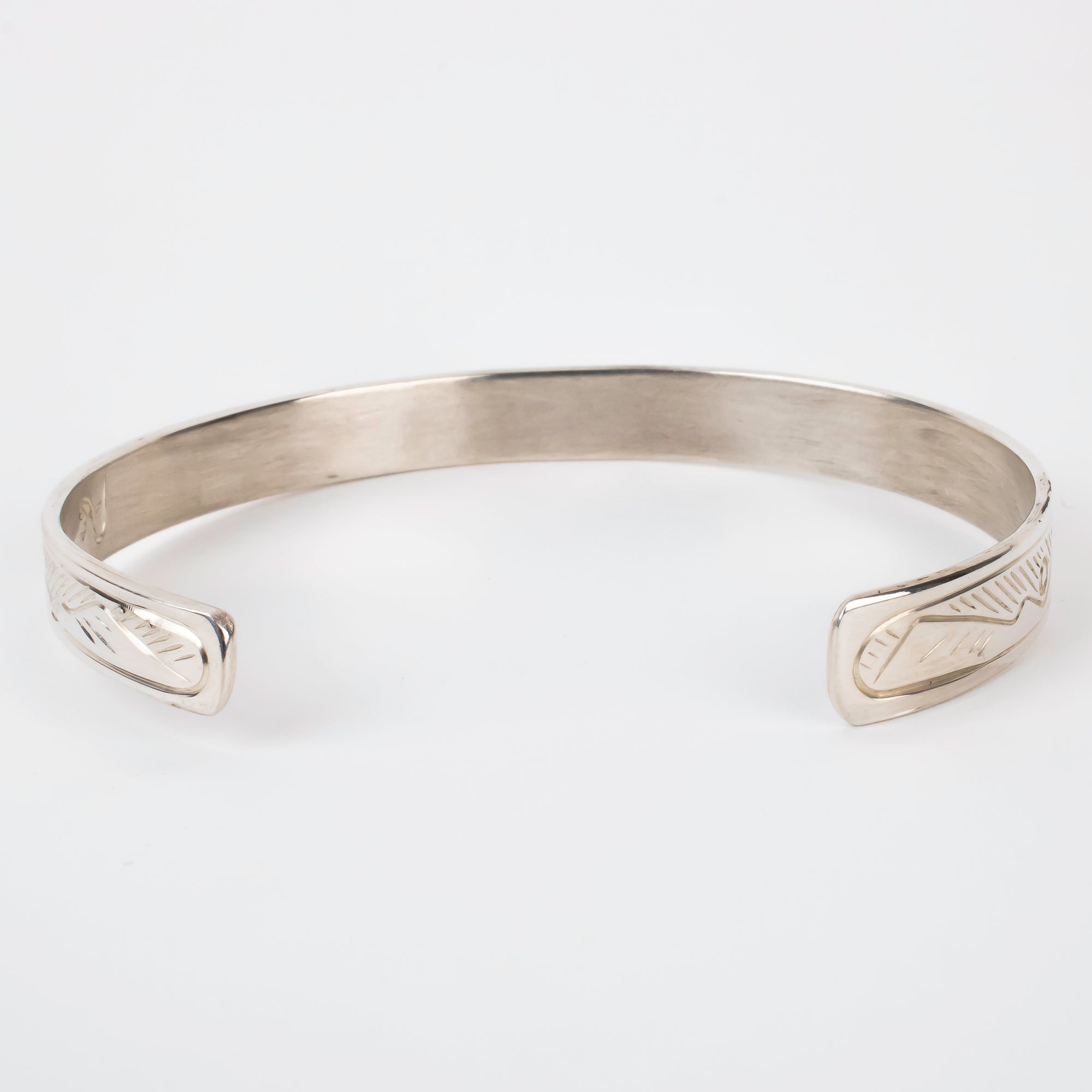 Back view of mountains on Sterling silver Bracelet featuring  14k gold formline wolf head, with mountains and trees hand carved around the bracelet