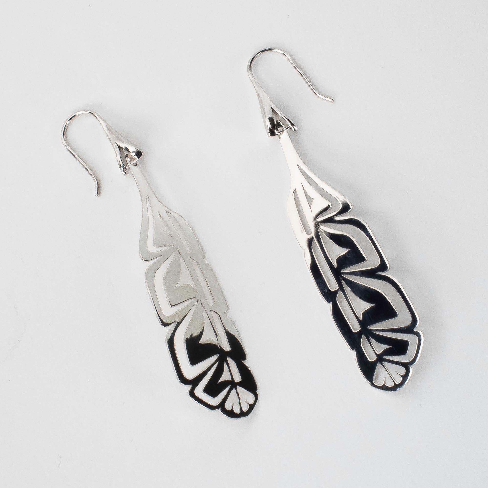 Laser engraved Sterling silver feather earrings, made by First nations artist, at a sideways angle