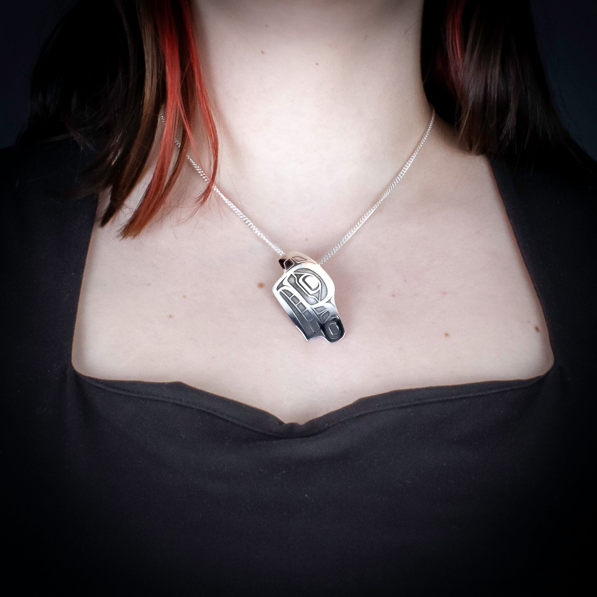 Sterling Silver Wolf Pendant by Canadian Handpoke tattoo artist Danika worn by a model