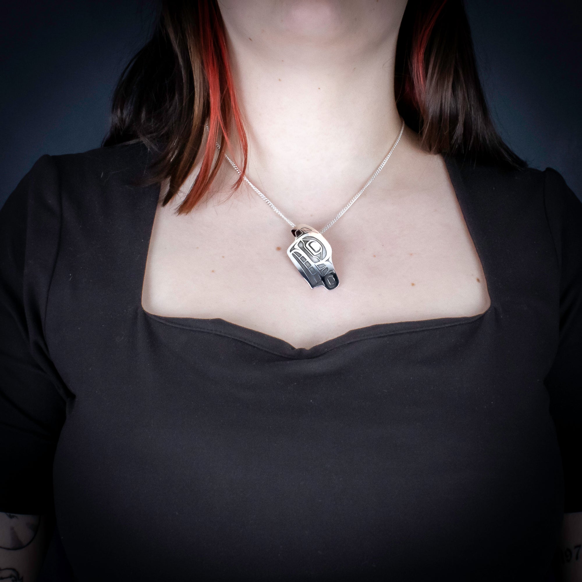 Sterling Silver Wolf Pendant by Canadian Handpoke tattoo artist Danika worn by a model