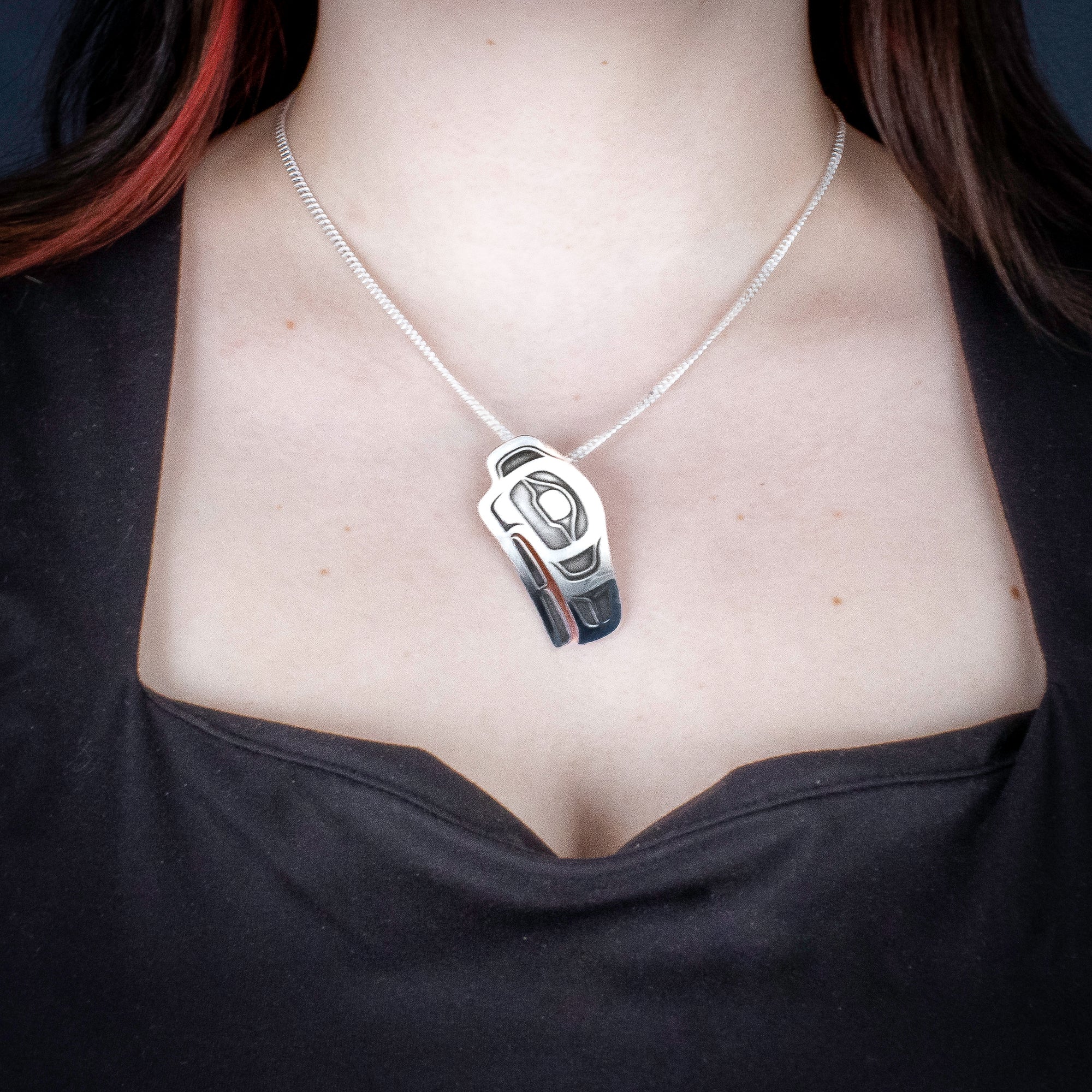 Sterling Silver Raven Pendant by Canadian Handpoke tattoo artist Danika worn by a model