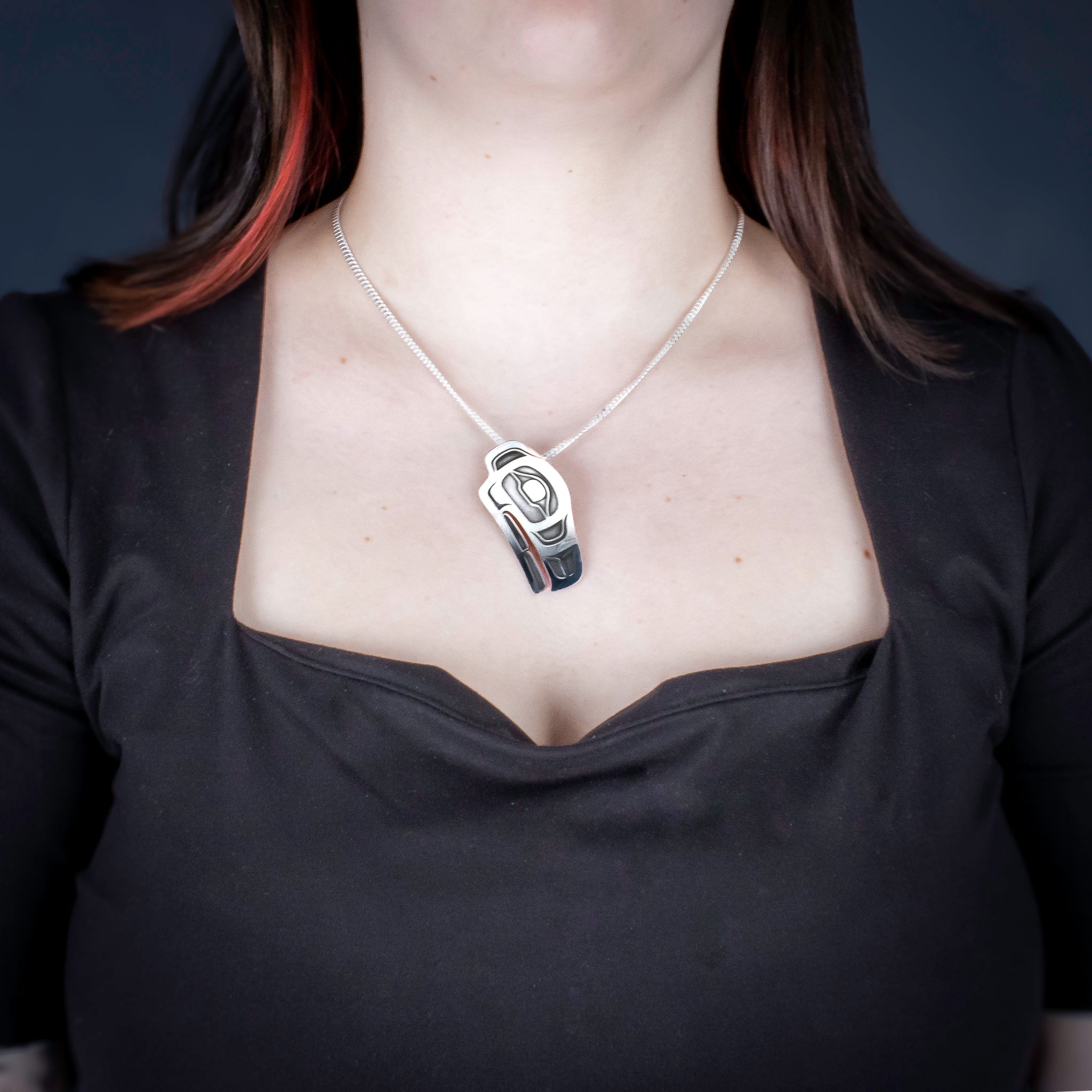 Sterling Silver Raven Pendant by Canadian Handpoke tattoo artist Danika worn by a model
