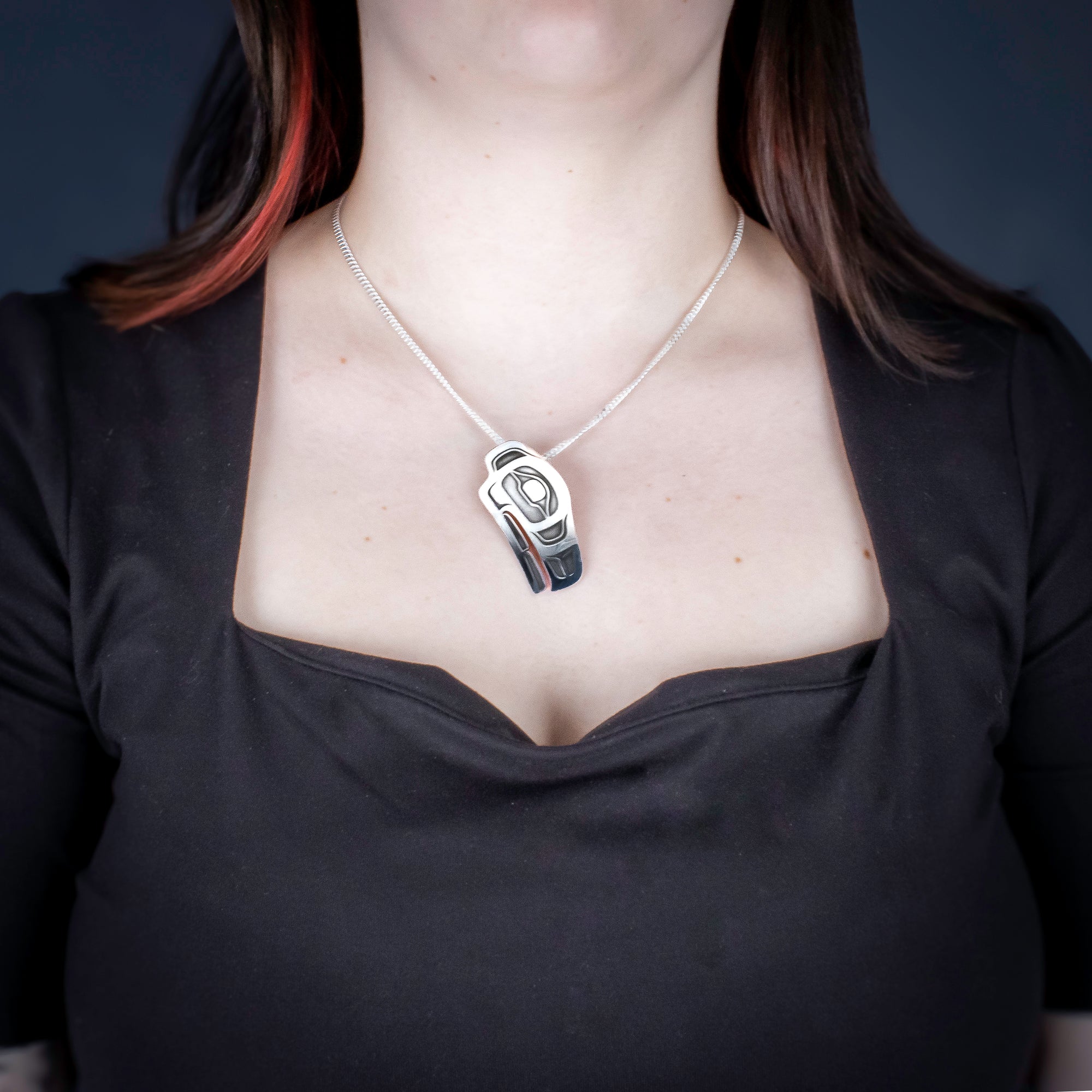 Sterling Silver Raven Pendant by Canadian Handpoke tattoo artist Danika worn by a model