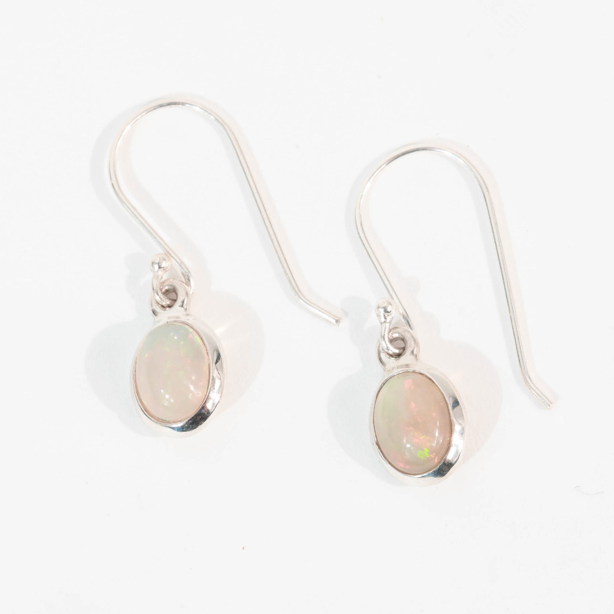 Pair of silver earrings with opal stones on a white background