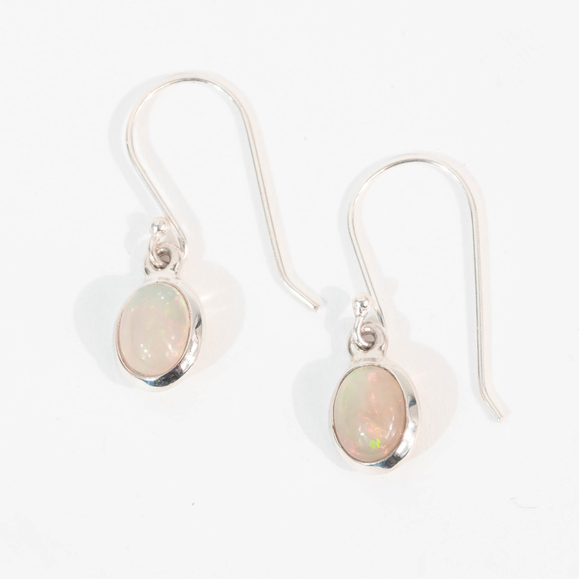 Pair of silver earrings with opal stones on a white background