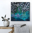 Abstract painting on a wall above a wooden bench with a vase and blanket.